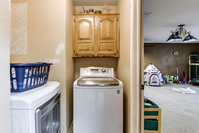 clothes washing area with cabinets, carpet, and independent washer and dryer