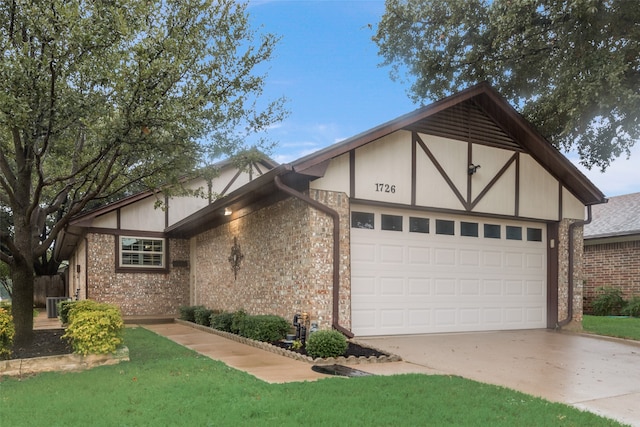 tudor-style house with cooling unit, a garage, and a front yard