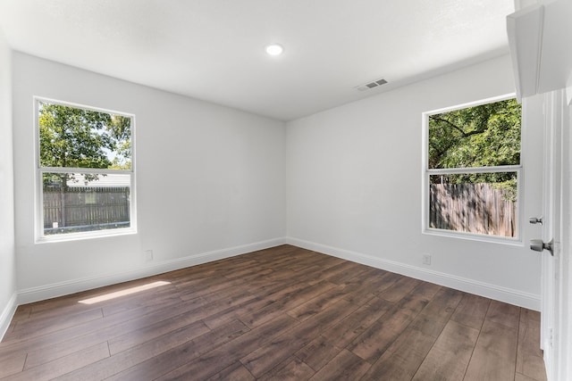 unfurnished room with a healthy amount of sunlight and dark hardwood / wood-style floors