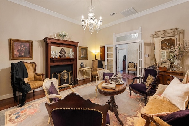 sitting room featuring an inviting chandelier, light wood-type flooring, crown molding, and french doors