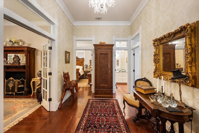 hall featuring hardwood / wood-style floors, crown molding, and a chandelier