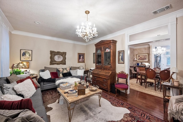 living room featuring a textured ceiling, a notable chandelier, ornamental molding, and dark wood-type flooring