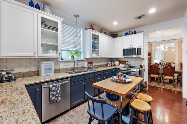 kitchen featuring sink, pendant lighting, stainless steel appliances, and blue cabinets