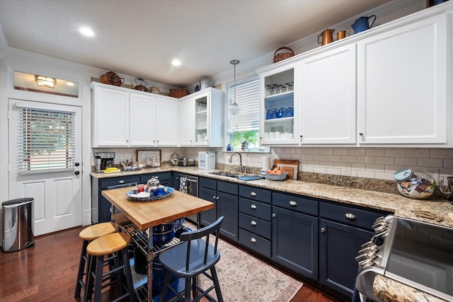 kitchen with appliances with stainless steel finishes, sink, blue cabinetry, white cabinets, and hanging light fixtures