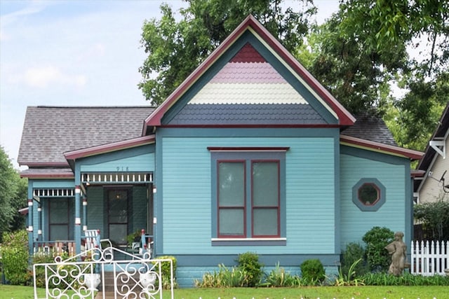 rear view of house featuring a porch and a yard