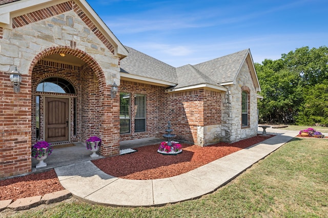 view of exterior entry with a lawn