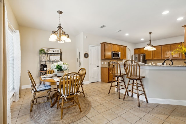 dining space with a chandelier and light tile patterned floors