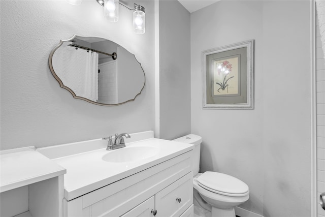 bathroom featuring vanity, toilet, and walk in shower