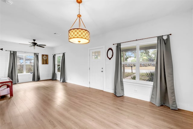 spare room featuring light wood-type flooring, a healthy amount of sunlight, and ceiling fan