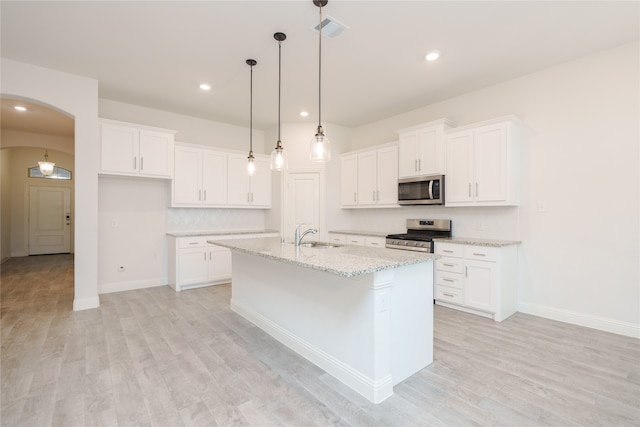 kitchen with white cabinetry, an island with sink, stainless steel appliances, and light hardwood / wood-style floors