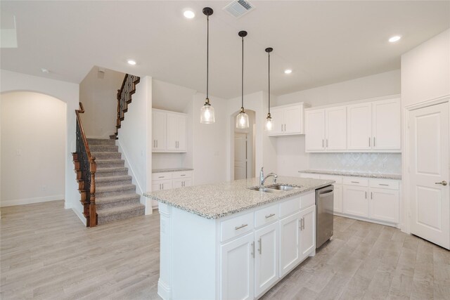 kitchen with white cabinetry, light hardwood / wood-style flooring, an island with sink, sink, and stainless steel dishwasher