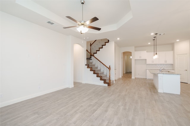 unfurnished living room featuring ceiling fan and light hardwood / wood-style flooring