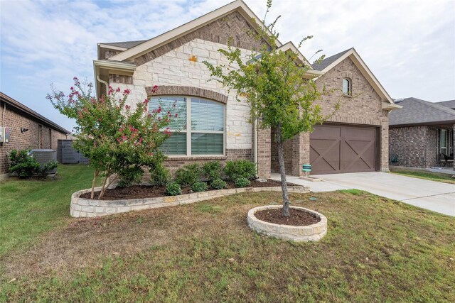 view of front of home with central air condition unit, a garage, and a front yard