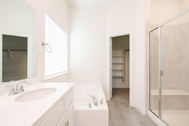 bathroom with a walk in closet, a bath, and a shower stall