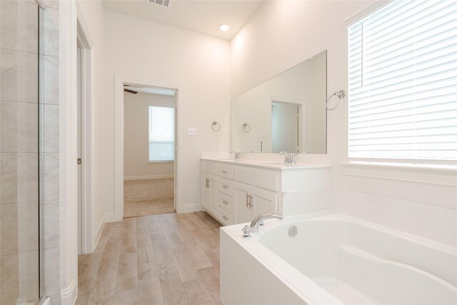 bathroom with separate shower and tub, hardwood / wood-style flooring, and vanity