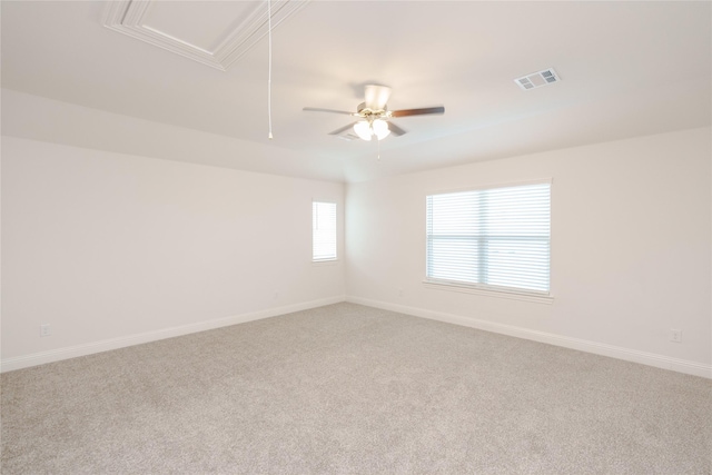 unfurnished room with light colored carpet, attic access, baseboards, and visible vents