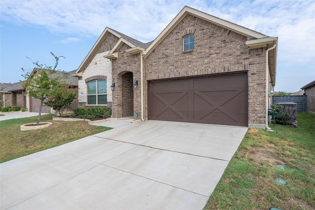 view of front facade featuring brick siding, concrete driveway, and a front yard