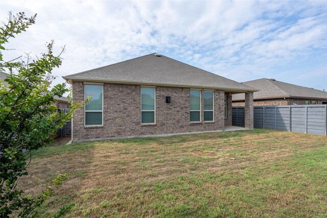 rear view of property featuring a lawn