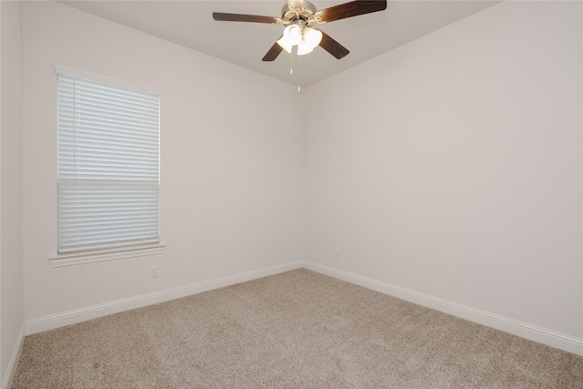 carpeted empty room featuring baseboards and a ceiling fan