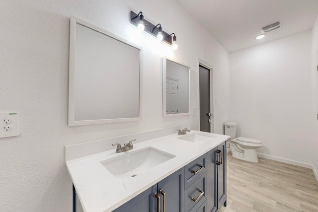 bathroom featuring toilet, hardwood / wood-style flooring, and vanity