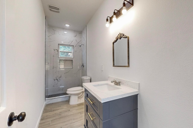 bathroom with an enclosed shower, hardwood / wood-style floors, toilet, and vanity