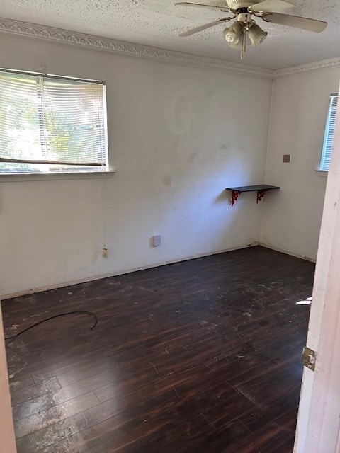 empty room featuring a textured ceiling, dark wood-type flooring, and ceiling fan