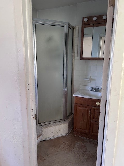 bathroom featuring vanity, an enclosed shower, and toilet