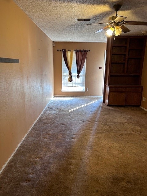 spare room featuring ceiling fan, carpet flooring, and a textured ceiling