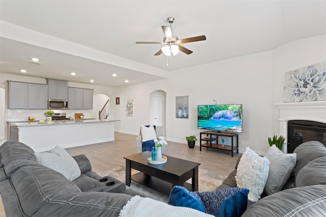 living room with ceiling fan and light wood-type flooring