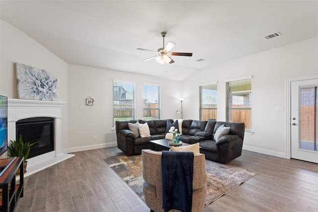 living room featuring ceiling fan, vaulted ceiling, and hardwood / wood-style flooring