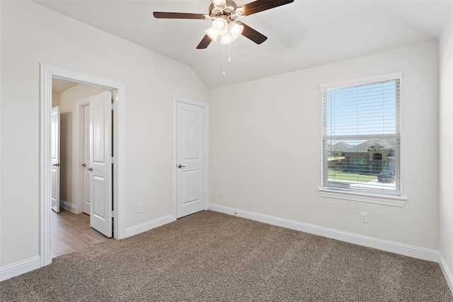 empty room with lofted ceiling, ceiling fan, and light hardwood / wood-style flooring