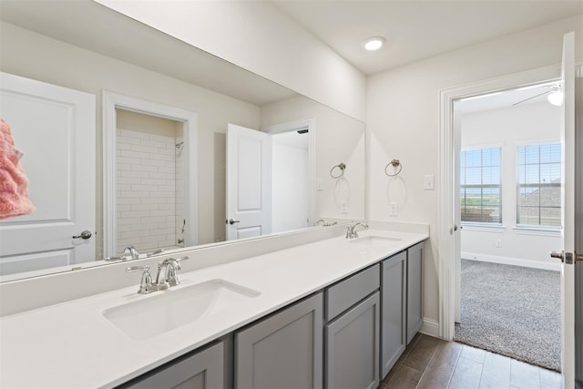 bathroom featuring vanity, a tile shower, and hardwood / wood-style floors