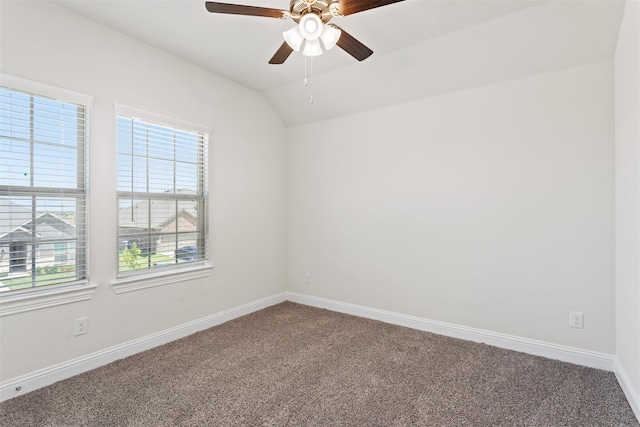 carpeted spare room featuring ceiling fan and vaulted ceiling