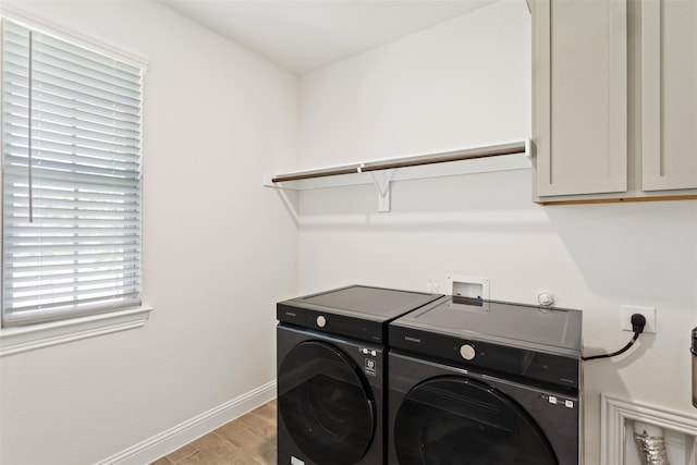 laundry room featuring light hardwood / wood-style flooring, cabinets, and separate washer and dryer