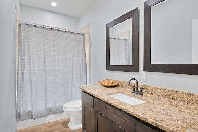 full bathroom featuring vanity, toilet, wood-type flooring, and shower / bath combo with shower curtain