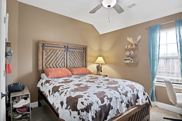 carpeted bedroom with ceiling fan and vaulted ceiling