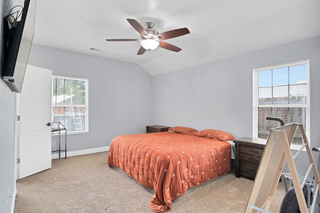 carpeted bedroom with lofted ceiling, ceiling fan, and multiple windows