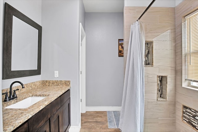 bathroom featuring walk in shower, vanity, plenty of natural light, and hardwood / wood-style floors