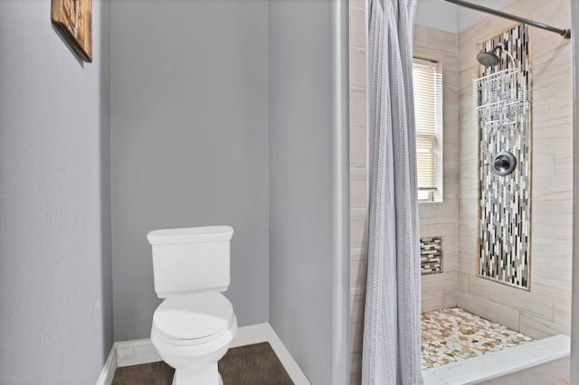 bathroom with a shower with shower curtain and toilet