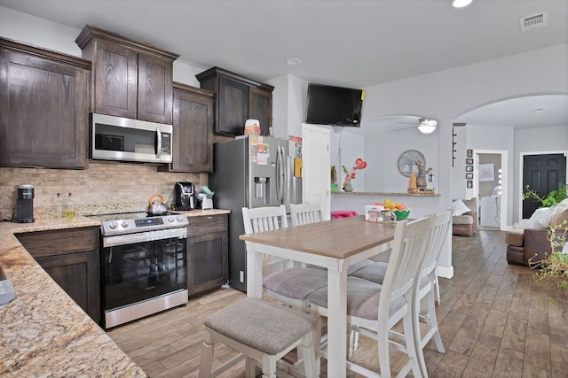 kitchen featuring ceiling fan, dark brown cabinetry, appliances with stainless steel finishes, and light hardwood / wood-style floors