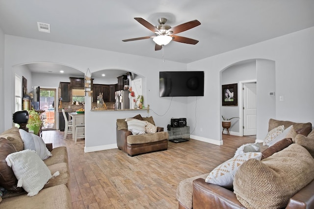 living room with ceiling fan and light wood-type flooring