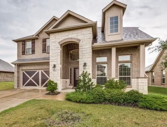 view of front of house featuring a garage and a front lawn