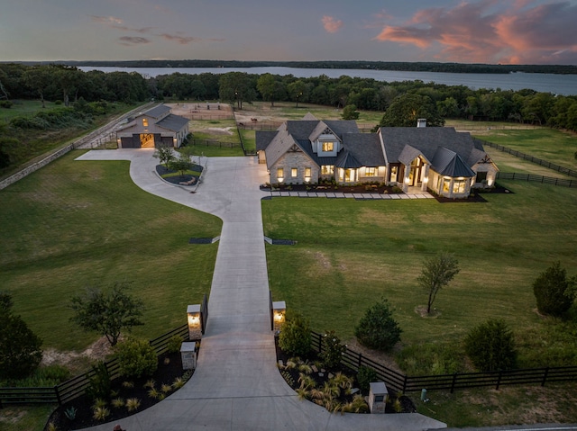 aerial view at dusk with a water view and a rural view