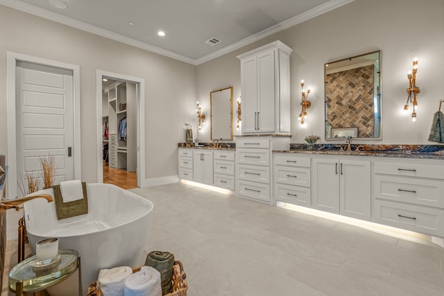 bathroom with a tub, tile patterned floors, crown molding, and vanity