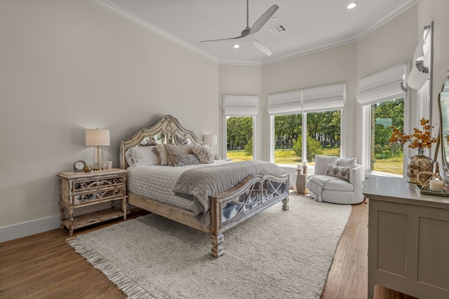 bedroom featuring crown molding, wood-type flooring, and ceiling fan