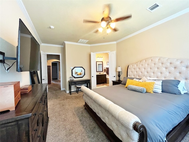 carpeted bedroom with ceiling fan, ornamental molding, and ensuite bathroom