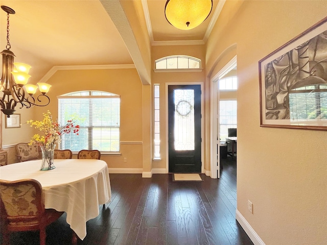 foyer entrance with a healthy amount of sunlight, ornamental molding, and dark hardwood / wood-style flooring