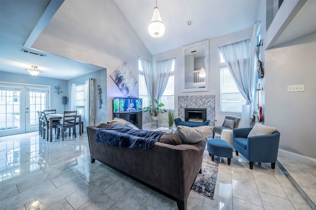 living room with a towering ceiling, an inviting chandelier, and light tile patterned floors