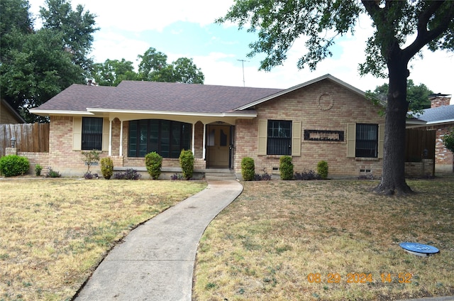 ranch-style house featuring crawl space, a front lawn, brick siding, and fence