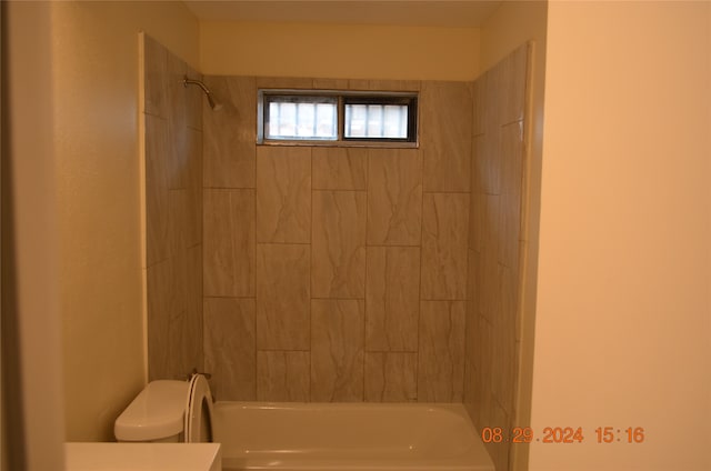 bathroom with tiled shower / bath and toilet